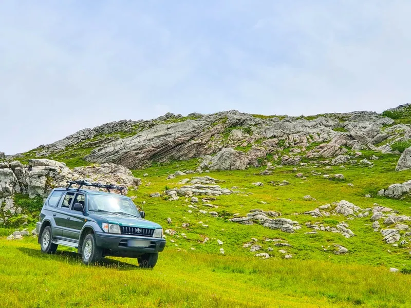 The 4x4 on green pasture among limestone outcrops